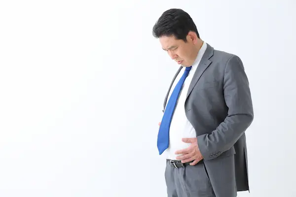 お腹をおさえる男性